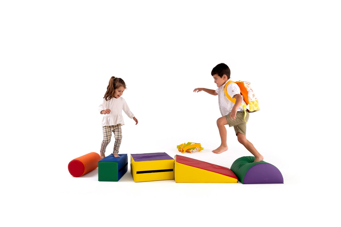Two young children playing on colourful foam blocks, with one wearing a Twisty Kids backpack. A fun, screen-free activity promoting creativity and active play.