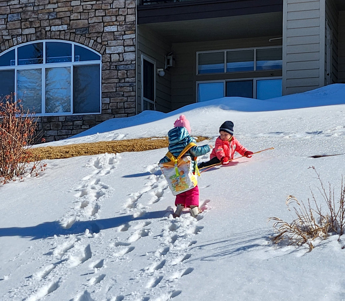 Two young children play in the snow near a house in the Australian Alps.