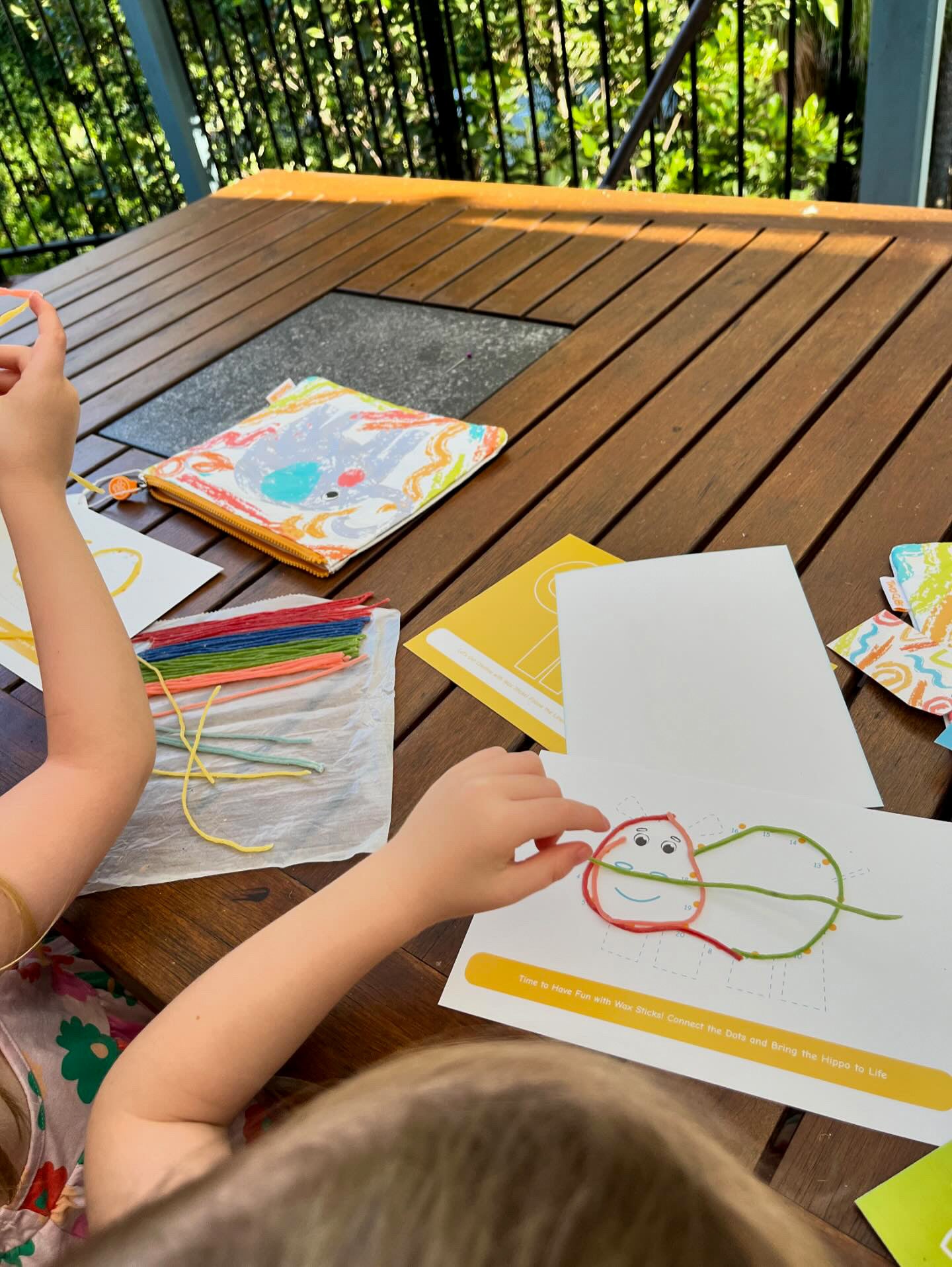 Child using colourful Twisty Kids wax sticks for fine motor skills activities and creative preschool play