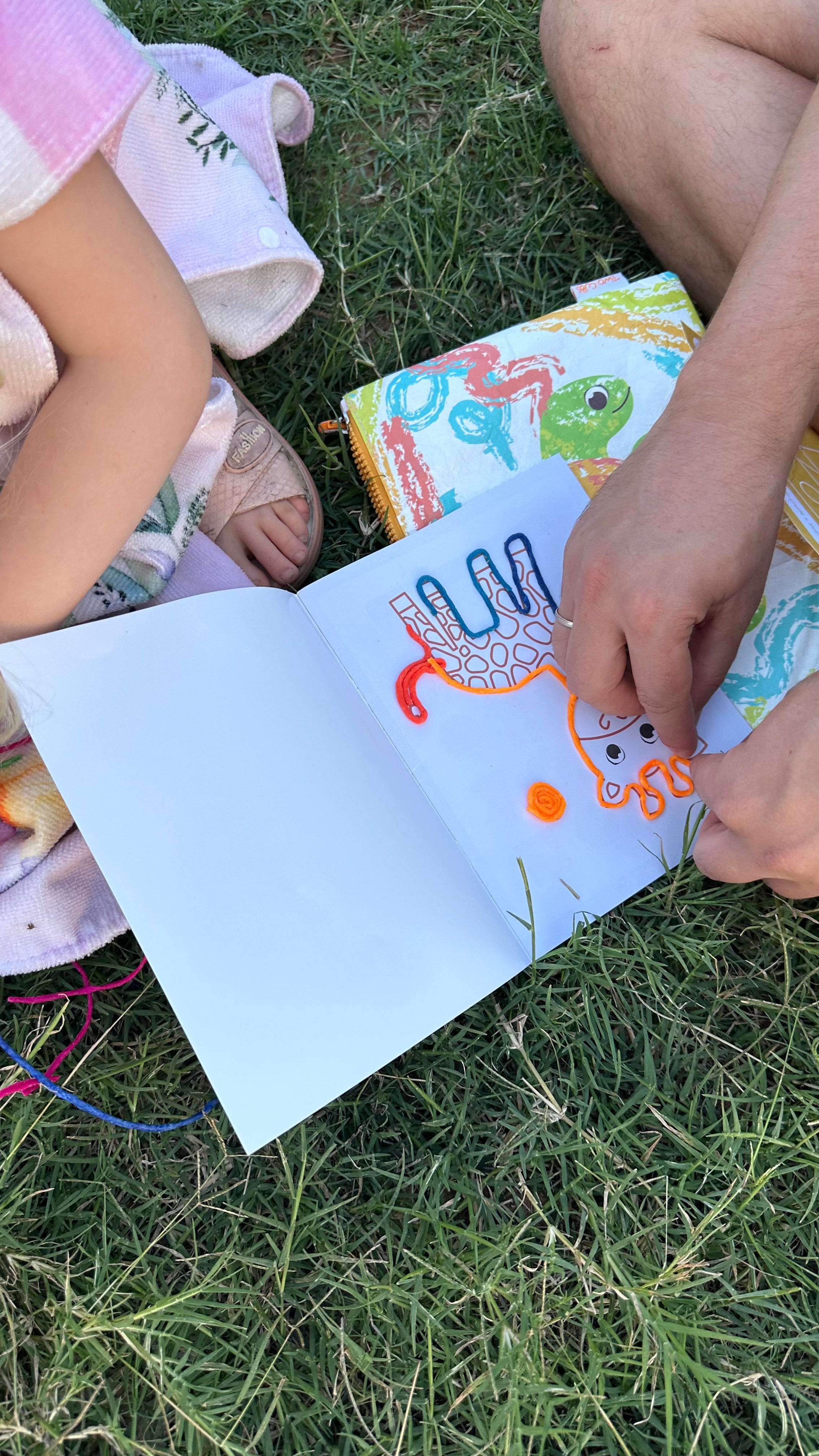 Child developing fine motor skills using colourful wax sticks for hands-on learning activity