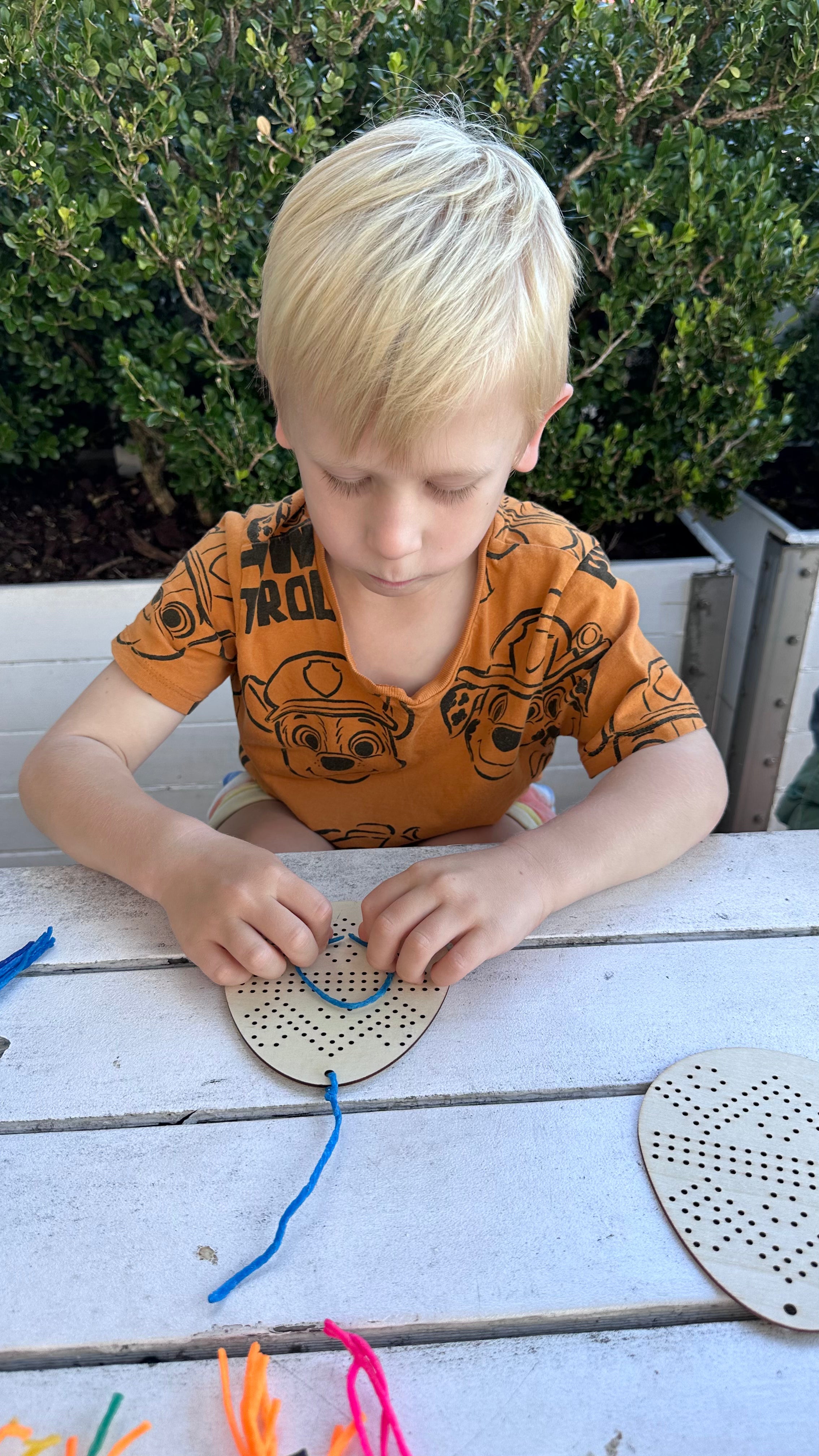 Child shaping flexible wax sticks during sensory play and fine motor skill development activity